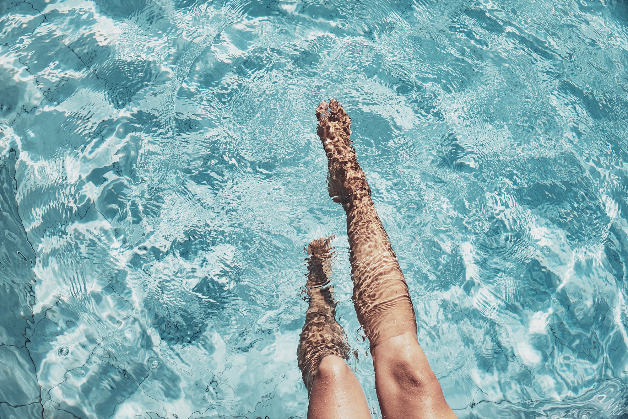woman's legs in swimming pool